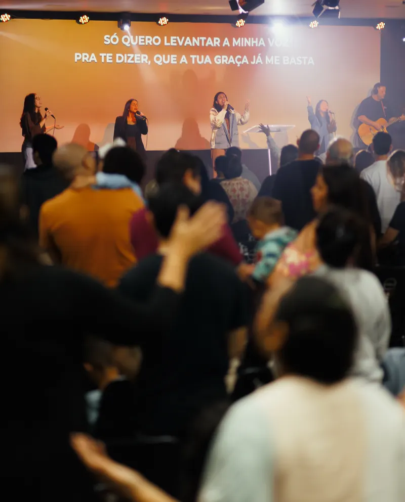 Congregação durante o louvor em um culto da Igreja Missão Emanuel