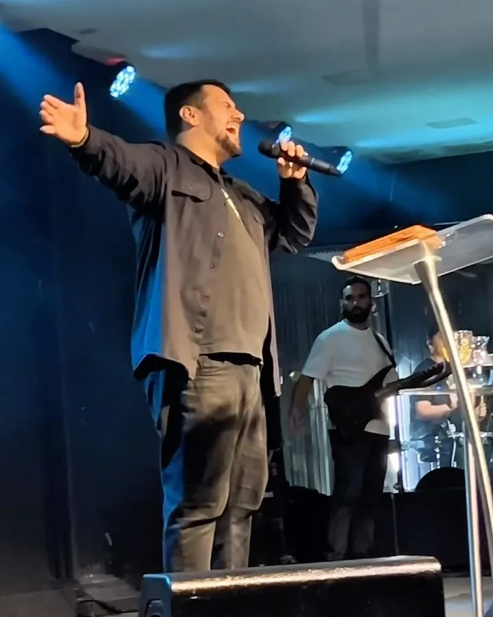 Ministração com as mãos erguidas durante um culto